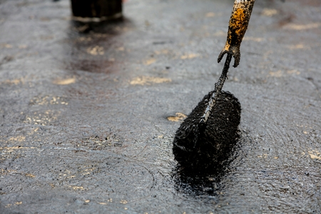 Flat roof installation. Heating and melting bitumen roofing felt.の写真素材