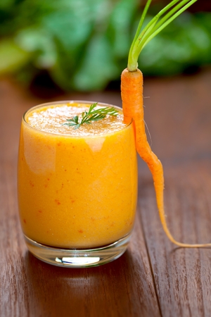 Carrot juice in glass and fresh carrots Healthy food on a grey stone background.の写真素材