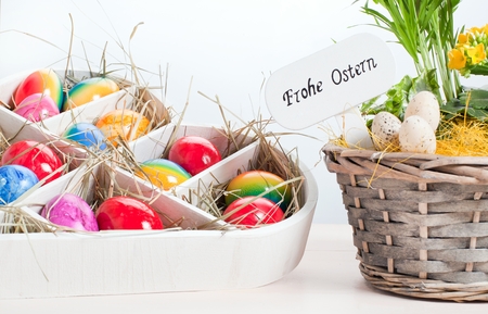 Multicolored easter eggs on vintage painted wooden background. German TEXT Happy Easter.の写真素材