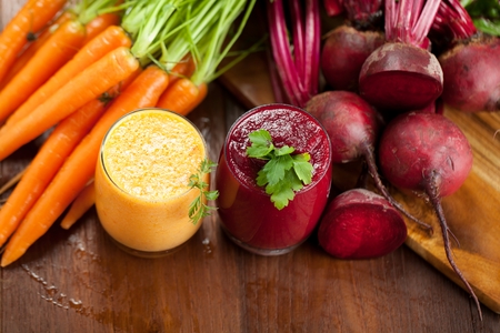 Mix beetroot and carrot juices on wooden backgroundの写真素材