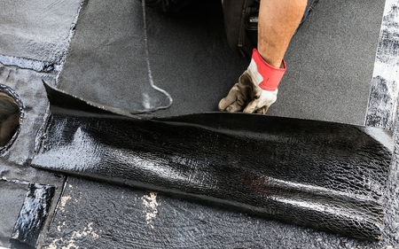 Flat roof installation. Heating and melting bitumen roofing felt.の写真素材