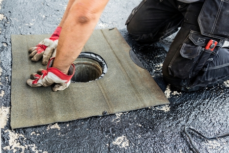 Flat roof installation. Heating and melting bitumen roofing felt.の写真素材