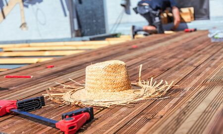 Handyman installing wooden flooring in patio, working with drilling machine.の写真素材