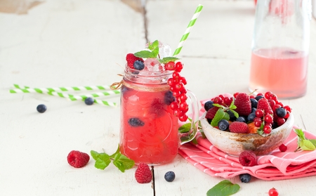 Summer Berry Drink. Lemonade with raspberry and blackberry with lemon, mint in mason jar on white table .の写真素材