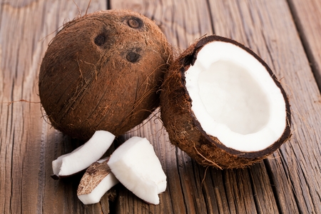 The halved coconut on old wooden backgroundの写真素材