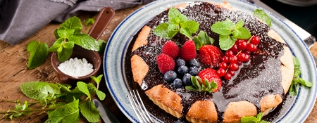 Delicious tart with fresh strawberries, raspberries and currants on the tableの写真素材