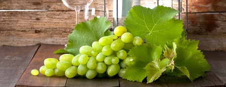 wine grapes on wooden background with wine corkの写真素材