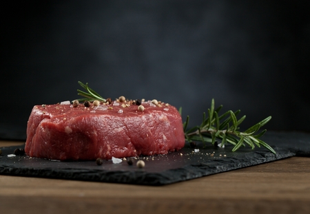 Raw beef steak on a dark wooden tableの写真素材