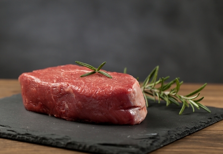 Raw beef steak on a dark wooden tableの写真素材