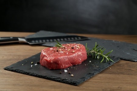 Raw beef steak on a dark wooden tableの写真素材