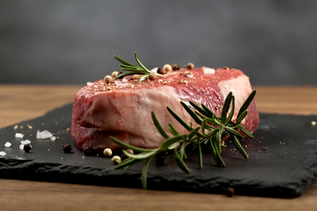 Raw beef steak on a dark wooden tableの写真素材