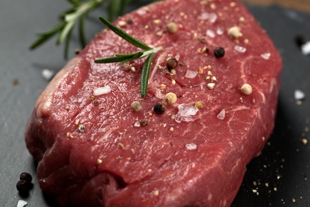 Raw beef steak on a dark wooden tableの写真素材