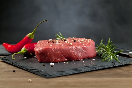Raw beef steak on a dark wooden tableの写真素材