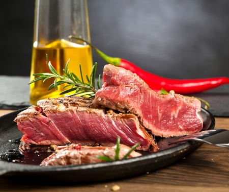 Fresh grilled meat. Grilled beef steak medium rare on wooden cutting board. Top view.の写真素材