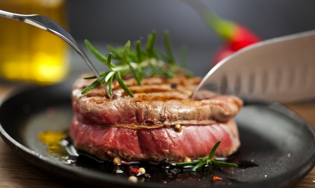 Fresh grilled meat. Grilled beef steak medium rare on wooden cutting board. Top view.の写真素材
