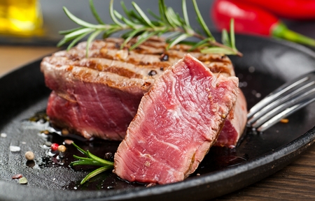 Fresh grilled meat. Grilled beef steak medium rare on wooden cutting board. Top view.の写真素材