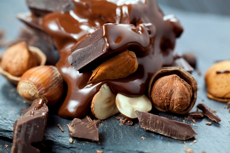melted chocolate pouring into a piece of chocolate bars on a tableの写真素材