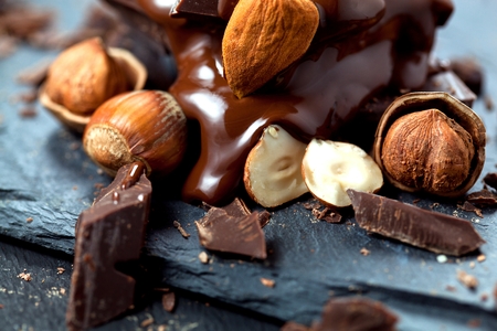 melted chocolate pouring into a piece of chocolate bars on a tableの写真素材