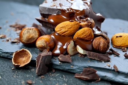 melted chocolate pouring into a piece of chocolate bars on a tableの写真素材