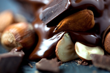 melted chocolate pouring into a piece of chocolate bars on a tableの写真素材