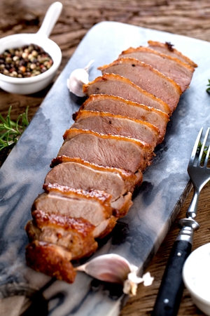 Duck breast fillet closeup on wooden background.の写真素材