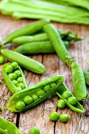 hearthy fresh green peas and pods on rustic wooden backgroundの写真素材