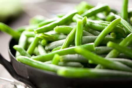 Heap of frozen pea on a old wooden table, top view.
