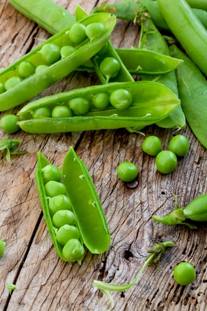hearthy fresh green peas and pods on rustic wooden backgroundの写真素材