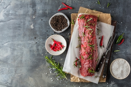 Raw beef steak on a dark beton tableの写真素材