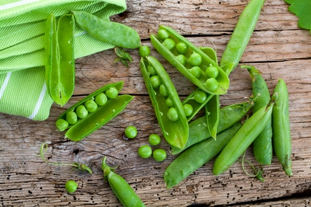 hearthy fresh green peas and pods on rustic wooden backgroundの写真素材