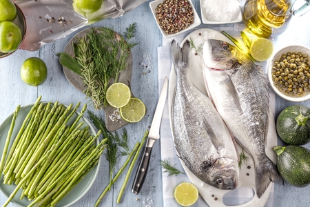 Fresh raw sea bream fish cooking on black stone countertop, top viewの写真素材