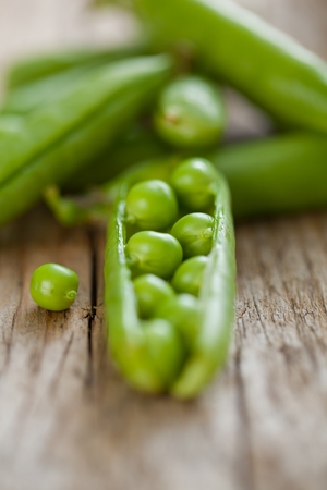 hearthy fresh green peas and pods on rustic wooden backgroundの写真素材