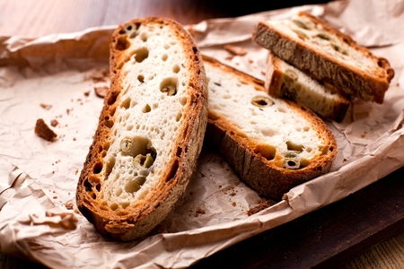 Italian style bread with olives close up on wooden table