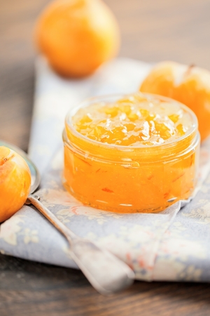 Studio shot of homemade small yellow plum mellow mirabelle jam in a glass jar and in a bowl.の写真素材