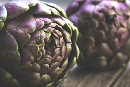 Fresh purple artichokes on dark rustic wooden backgroundの写真素材