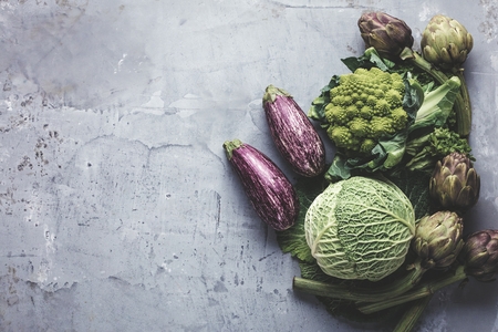 Top view on fresh vegetables arranged around border on grey kitchen countertop.の写真素材
