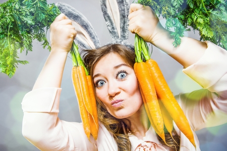 Funny woman with fresh carrot. Picture with space for your text.の写真素材