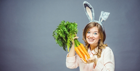 Funny woman with fresh carrot. Picture with space for your text.