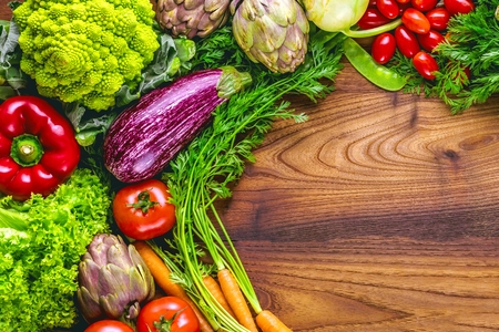 Assortment of fresh fruits and vegetables on dark wooden background with copy space