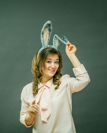 Festive bunny and eggs season. happy modern woman in Easter bunny ears isolated on grey background.