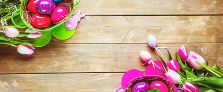 Easter eggs and tulips on wooden planks with German text Happy Easter