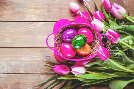 Easter eggs and tulips on wooden planks with German text Happy Easter