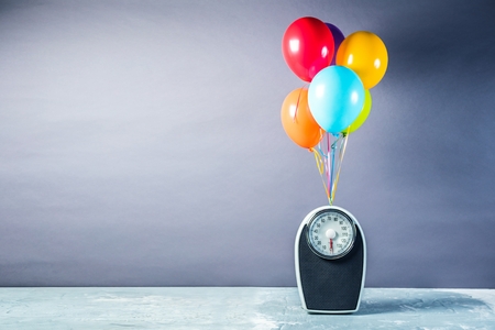 Bathroom scales with colorful balloons. Slimming concept.の写真素材