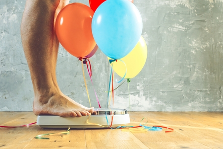 Bathroom scales with colorful balloons. Slimming concept.の写真素材