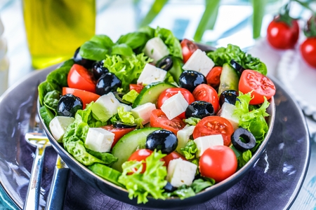Fresh vegetables greek salad . Healthy food on wooden backgroundの写真素材