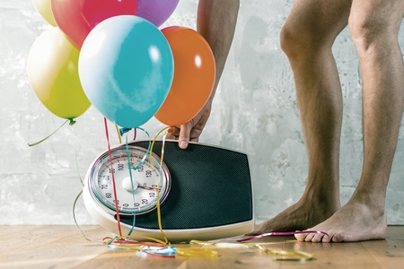 Bathroom scales with colorful balloons. Slimming concept.の写真素材