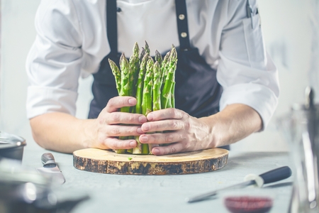 Green asparagus kept in men's Chef cook handsの写真素材