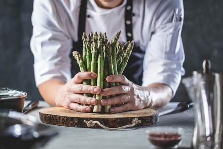 Green asparagus kept in men's Chef cook handsの写真素材