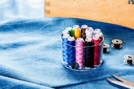 background table top view of sewing tool and jeans on denim fabric.の写真素材