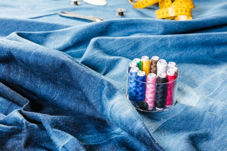 background table top view of sewing tool and jeans on denim fabric.の写真素材